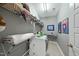 Functional laundry room with washer, dryer, ironing board, and storage shelving at 233 Pointe Park Cir, Holly Springs, NC 27540