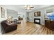 Inviting living room with a fireplace, hardwood floors, and open layout to the kitchen at 233 Pointe Park Cir, Holly Springs, NC 27540