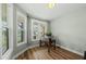 Bright home office featuring large windows, a wooden desk, and hardwood floors at 233 Pointe Park Cir, Holly Springs, NC 27540
