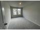 Bright bedroom with neutral walls, plush gray carpet, and natural light from two windows at 236 Paramount Dr, Smithfield, NC 27577