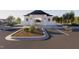 View of the grand community entrance with manicured landscaping, visitor parking, and a covered entryway at 255 Meadowbark Bnd # 31, Garner, NC 27529