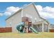 Spacious backyard featuring a large playset, lush green lawn and screened in porch in view at 2613 Red Spruce Dr, Raleigh, NC 27616