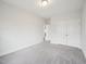 Bright bedroom with neutral walls and plush carpeting, next to a door and closet with double doors at 2613 Red Spruce Dr, Raleigh, NC 27616
