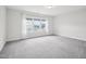 Bedroom with a large window to let light in and neutral carpeted flooring and white walls at 2613 Red Spruce Dr, Raleigh, NC 27616