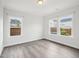 Light filled bedroom with hardwood flooring, white walls, with three windows that bring the outdoors in at 2613 Red Spruce Dr, Raleigh, NC 27616