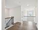 Hallway with rich flooring, contrasting white walls and baseboards, staircase, and attractive railings at 2613 Red Spruce Dr, Raleigh, NC 27616