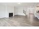 Spacious living room featuring a fireplace, wood floors, a staircase, and plenty of natural light at 2613 Red Spruce Dr, Raleigh, NC 27616
