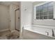 Bright bathroom featuring a large soaking tub next to a window and glass shower at 263 Annali Way, Wendell, NC 27591