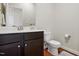Cozy half bathroom featuring a dark vanity with marble top and dark hardwood-style floors at 263 Annali Way, Wendell, NC 27591
