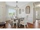 Elegant dining room with white chairs, dark wood table, light fixture, and decorative accents at 263 Annali Way, Wendell, NC 27591