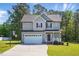 Well-maintained two-story home with attached garage, front porch with rocking chairs, and landscaping at 263 Annali Way, Wendell, NC 27591