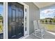 Inviting porch with rocking chairs next to a black front door with digital entry and white trim at 263 Annali Way, Wendell, NC 27591