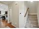 Hallway featuring carpeted stairs, hardwood floors, and an open view into the kitchen area at 263 Annali Way, Wendell, NC 27591