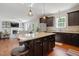 Open kitchen featuring a center island with granite countertops, dark cabinetry, and stainless steel appliances at 263 Annali Way, Wendell, NC 27591