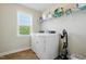 Well-lit laundry room with modern washer and dryer, storage shelves, and natural light from the window at 263 Annali Way, Wendell, NC 27591