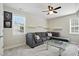 Bright living area with a gray sectional, glass coffee table, and a ceiling fan at 263 Annali Way, Wendell, NC 27591