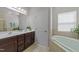 Bright bathroom with a double sink vanity, soaking tub, and tile flooring at 316 Hilliard Forest Dr, Cary, NC 27519