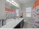 Bright bathroom featuring a large mirror, dark vanity and butterfly-themed shower curtain at 316 Hilliard Forest Dr, Cary, NC 27519