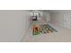 Bright bonus room with neutral carpet and a colorful alphabet play mat near the staircase at 316 Hilliard Forest Dr, Cary, NC 27519