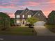 Brick two-story home with landscaped front yard, front porch and attached two-car garage at sunset at 316 Hilliard Forest Dr, Cary, NC 27519