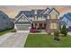 Beautiful two-story home with stone accents, manicured lawn, and inviting front porch at 3205 Silver Ore Ct, Wake Forest, NC 27587