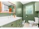 Bathroom featuring a large vanity with modern fixtures, a window, and stylish green walls at 329 Cartwright Cir, Wendell, NC 27591