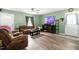 Cozy living room with a comfortable leather sofa, ceiling fan, and neutral walls and flooring at 329 Cartwright Cir, Wendell, NC 27591