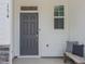 Front door entrance with an outdoor bench and decorative pillow at 373 Thompson Overlook Way # 233, Smithfield, NC 27577