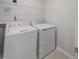 Bright laundry room with white washer, dryer, wire shelving, and neutral walls at 373 Thompson Overlook Way # 233, Smithfield, NC 27577