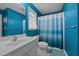 Bright bathroom featuring a white vanity, toilet, and a blue and white shower curtain at 3809 Long Meadow Dr, Mebane, NC 27302