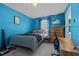 Comfortable bedroom featuring blue walls, carpet flooring, a wooden desk, and a window for natural light at 3809 Long Meadow Dr, Mebane, NC 27302