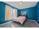 Cozy bedroom featuring blue walls, carpet flooring, and a window with bright natural light at 3809 Long Meadow Dr, Mebane, NC 27302