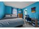 Comfortable bedroom with blue walls, carpet flooring, wooden desk, and view of an adjacent bathroom at 3809 Long Meadow Dr, Mebane, NC 27302