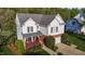 Two-story home with white siding, brick accents, lush landscaping, and a two-car garage at 3809 Long Meadow Dr, Mebane, NC 27302