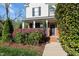 Inviting front porch with brick accents and colorful landscaping leading to a welcoming entrance at 3809 Long Meadow Dr, Mebane, NC 27302