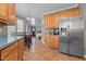Spacious kitchen with oak cabinets, stainless steel refrigerator, and open layout leading to other living spaces at 3809 Long Meadow Dr, Mebane, NC 27302