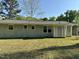 A charming single story home with a gray brick back exterior and verdant landscaping under a clear blue sky at 3815 Weyburn Rd, Durham, NC 27704