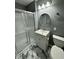 This bathroom features a stand-up shower, marble floors, and a modern vanity with a round mirror at 3815 Weyburn Rd, Durham, NC 27704