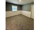 Comfortable bedroom with carpet, white wainscoting, and natural light from a window at 3815 Weyburn Rd, Durham, NC 27704