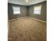Cozy bedroom featuring neutral carpeting and ample natural light from two windows at 3815 Weyburn Rd, Durham, NC 27704