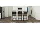 Charming kitchen with black and white color palette, featuring bar stool seating and modern stainless-steel appliances at 385 Thompson Overlook Way # 236, Smithfield, NC 27577
