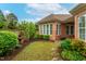 Lush, private backyard with mature trees, a small fountain, and a brick wall at 4 Calwell Creek Dr, Chapel Hill, NC 27517