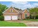 Charming brick home with well-manicured lawn, two-car garage, and eye-catching green shutters at 4 Calwell Creek Dr, Chapel Hill, NC 27517