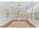 Sunroom with hardwood floors, two chairs, a ceiling fan, and lots of windows at 4 Calwell Creek Dr, Chapel Hill, NC 27517