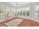 Sunroom with hardwood floors, two chairs, a ceiling fan, and lots of windows at 4 Calwell Creek Dr, Chapel Hill, NC 27517