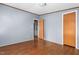 A bedroom features wood-look flooring, a gray paneled wall, and two wooden doors at 4047 Mistletoe Dr, Burlington, NC 27217