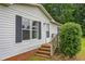 Close-up of the front entrance with brick steps and a well-maintained lawn at 4047 Mistletoe Dr, Burlington, NC 27217