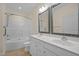 Bathroom with double vanity, tile backsplash, framed mirrors, shower over tub, and tiled floor at 4105 Gilchrist Dr, Burlington, NC 27215