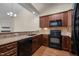 Modern kitchen with dark wood cabinets, granite countertops, black appliances, and tile backsplash at 4105 Gilchrist Dr, Burlington, NC 27215