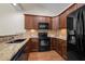 Well-lit kitchen featuring granite counters, tile backsplash, stainless appliances, and wood flooring at 4105 Gilchrist Dr, Burlington, NC 27215
